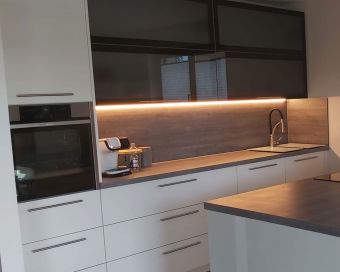 Moderne Einbauküche mit LED-Beleuchtung, dunklen Glastüren und maßgefertigten Fronten – Küchenlösung in Köln und Leverkusen